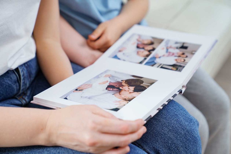 mother and her son looking at their photos in a photo book